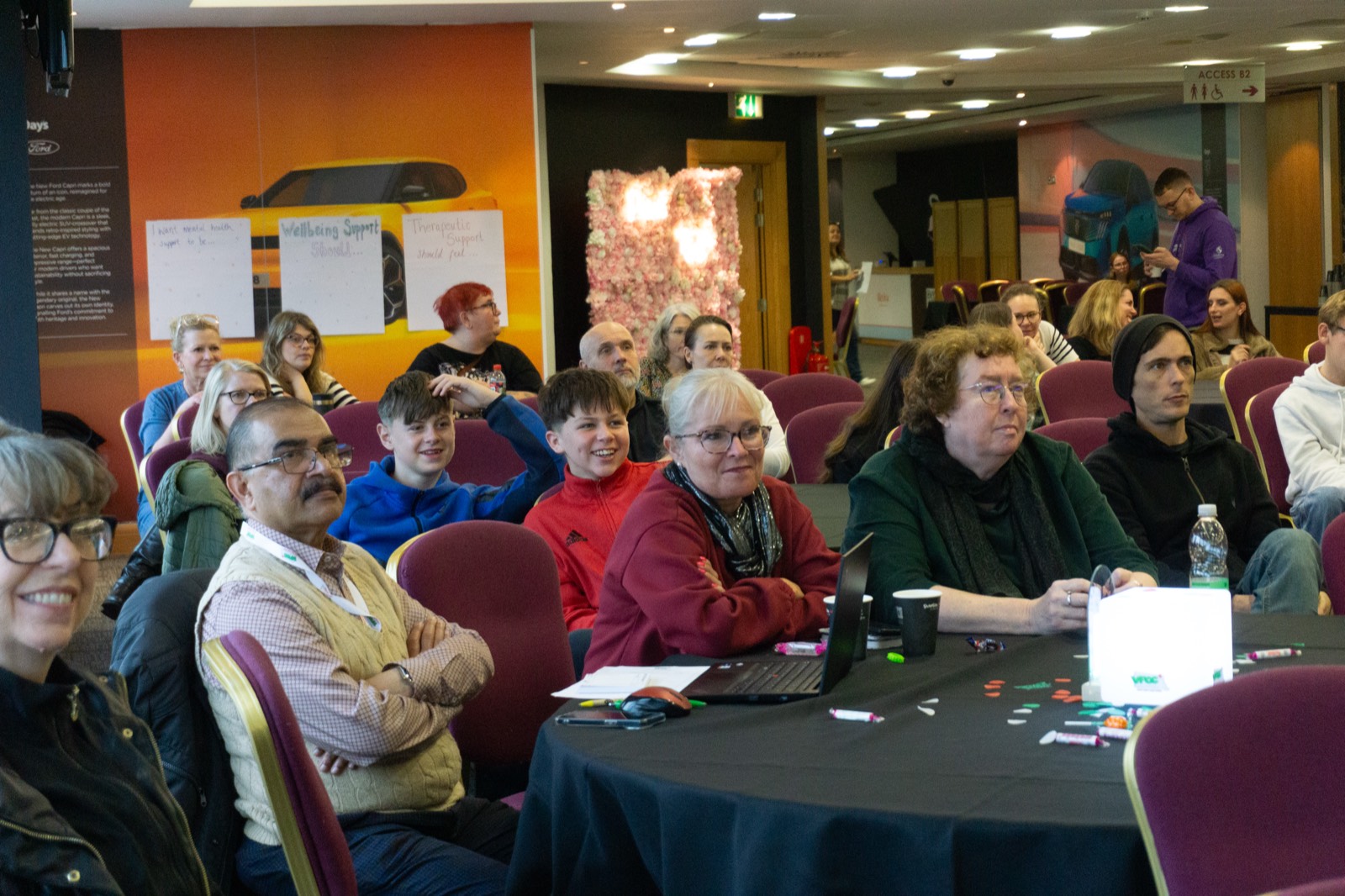 Audience seated at tables during a Proud to Be Me event