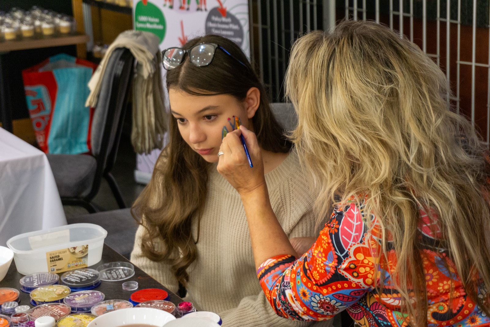 A young person getting face painted at a VFCC community event
