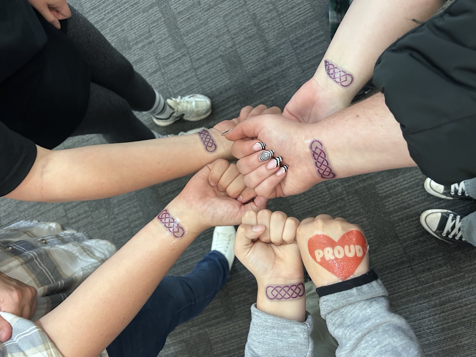 Young people showing matching Celtic tattoos and Proud stamps at a VFCC event